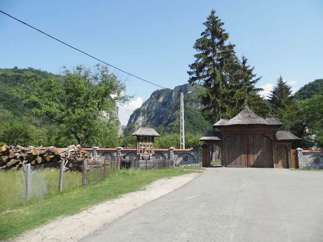 Drumul spre poarta de lemn a Mănăstirii Polovragi, cu stâncile cheilor în spate