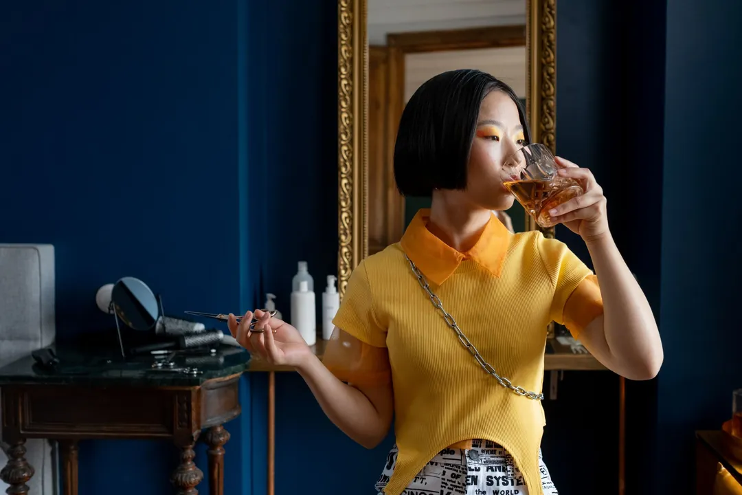 A client at a gilt mirror in a dark blue salon
