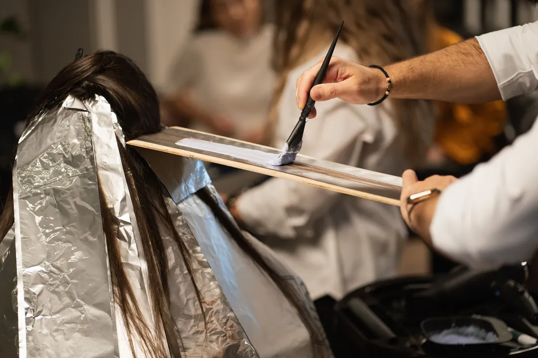 Margot at work: Lightener painted onto a section of hair over foil