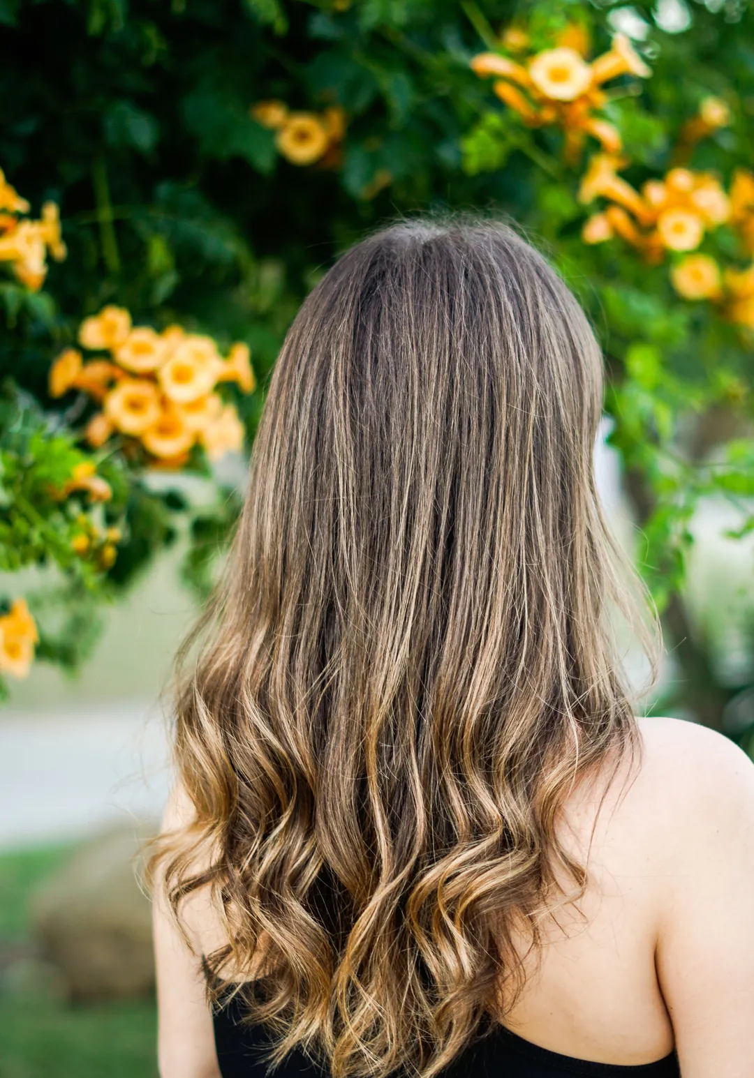Soft blonde balayage waves seen from behind