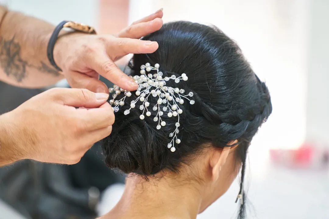 Isla at work: Hands pinning a crystal comb into dark hair