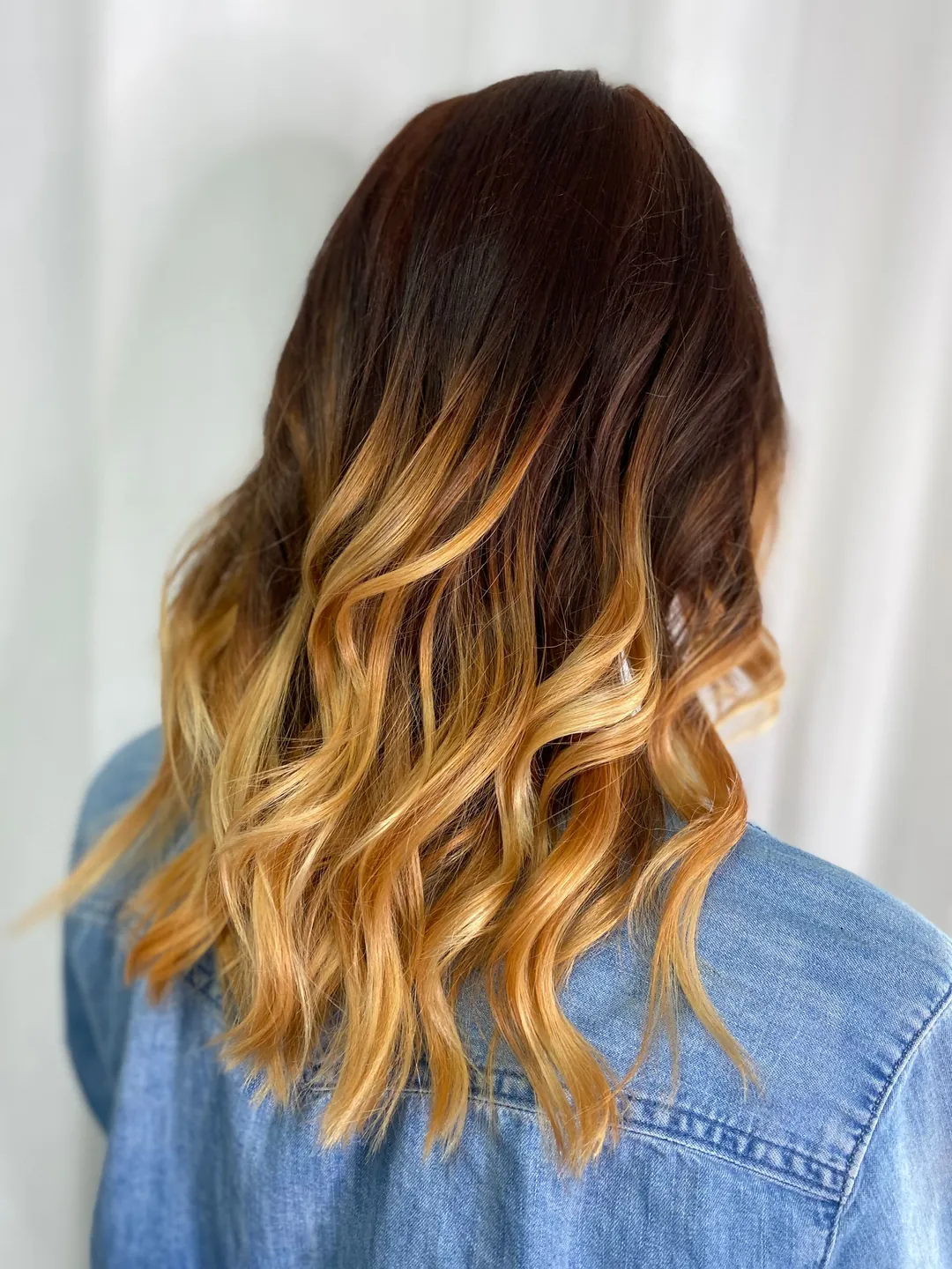 Dark roots melting into copper-gold waves