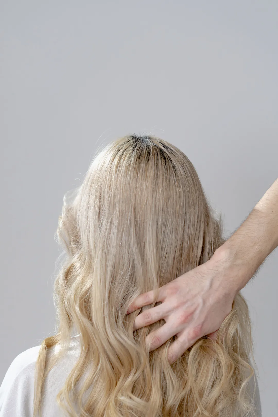 A hand in long blonde waves