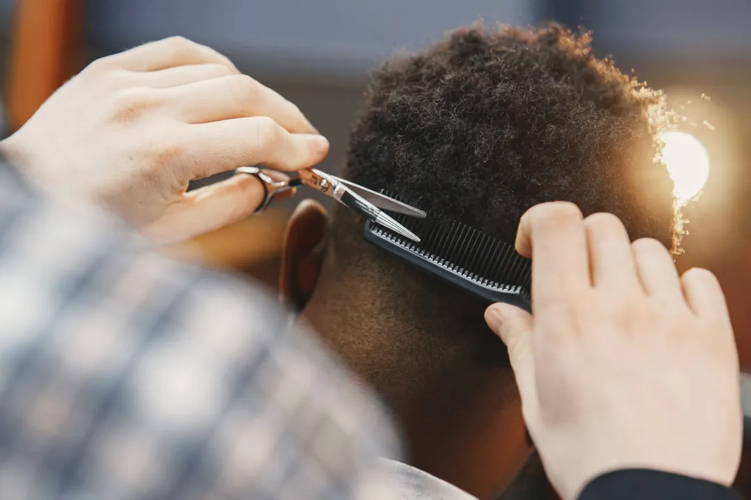 Kit at work: A short cut being finished with scissors over a comb