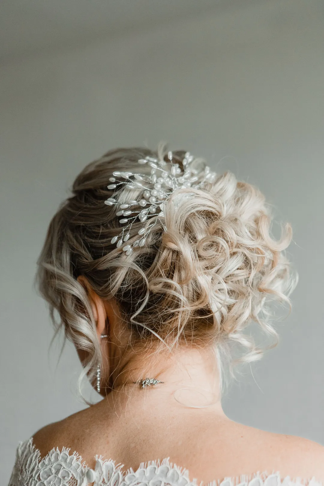A textured bridal upstyle with a crystal hair vine