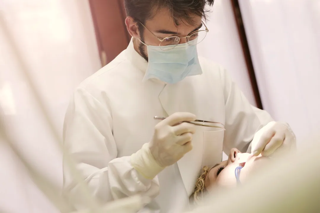 A dentist at work beside a softly lit window