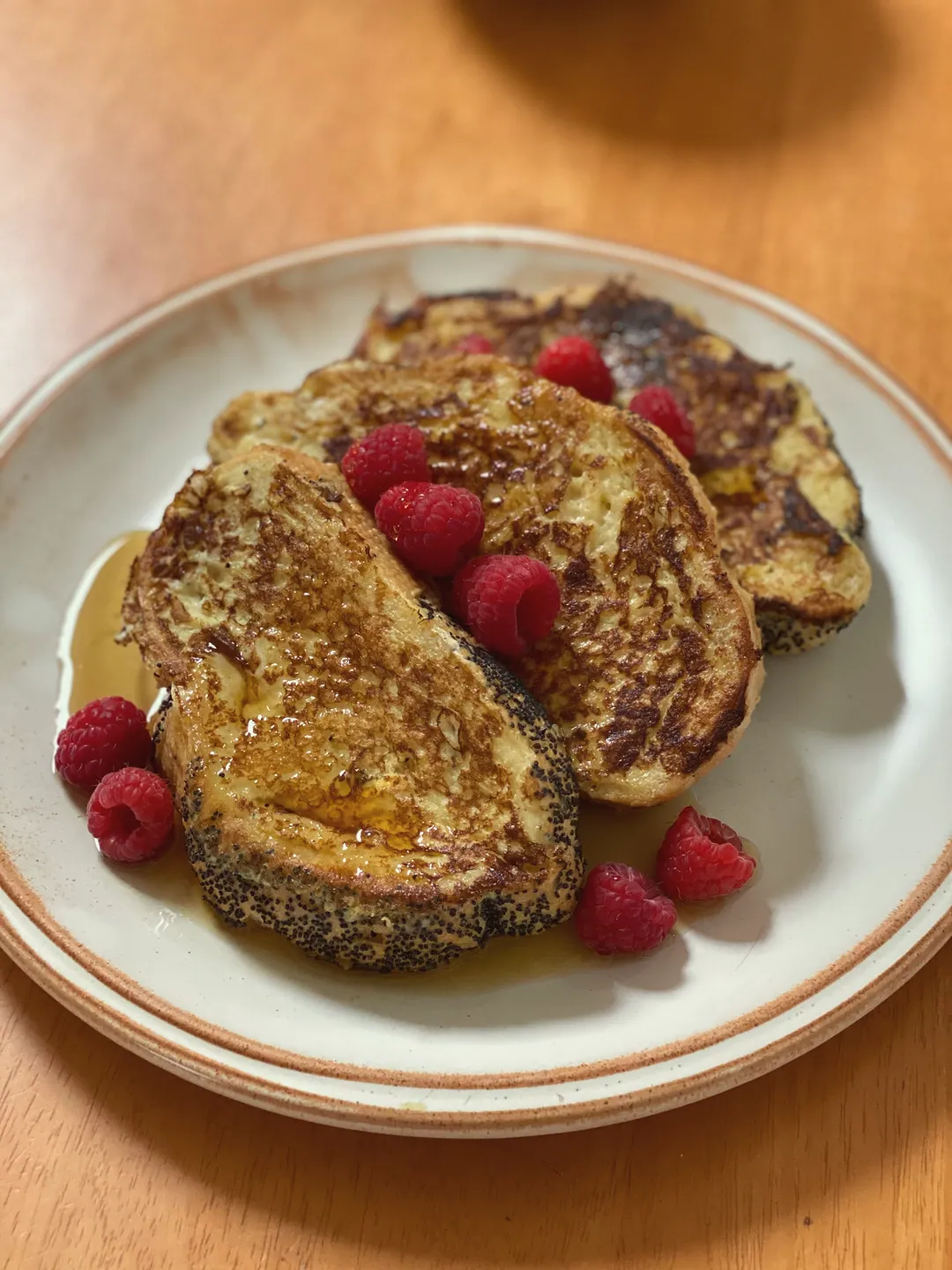 French toast with raspberries on a white plate