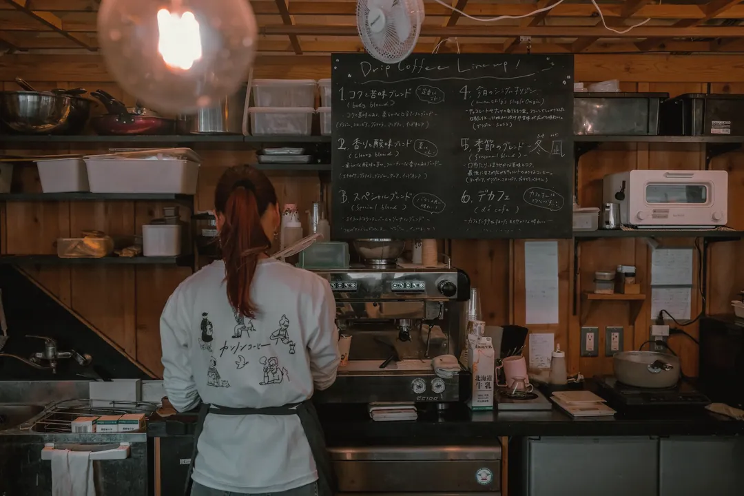 A barista at the espresso machine, seen from behind