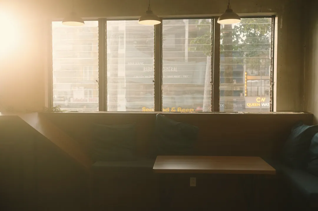 A window booth with morning light coming through the blinds