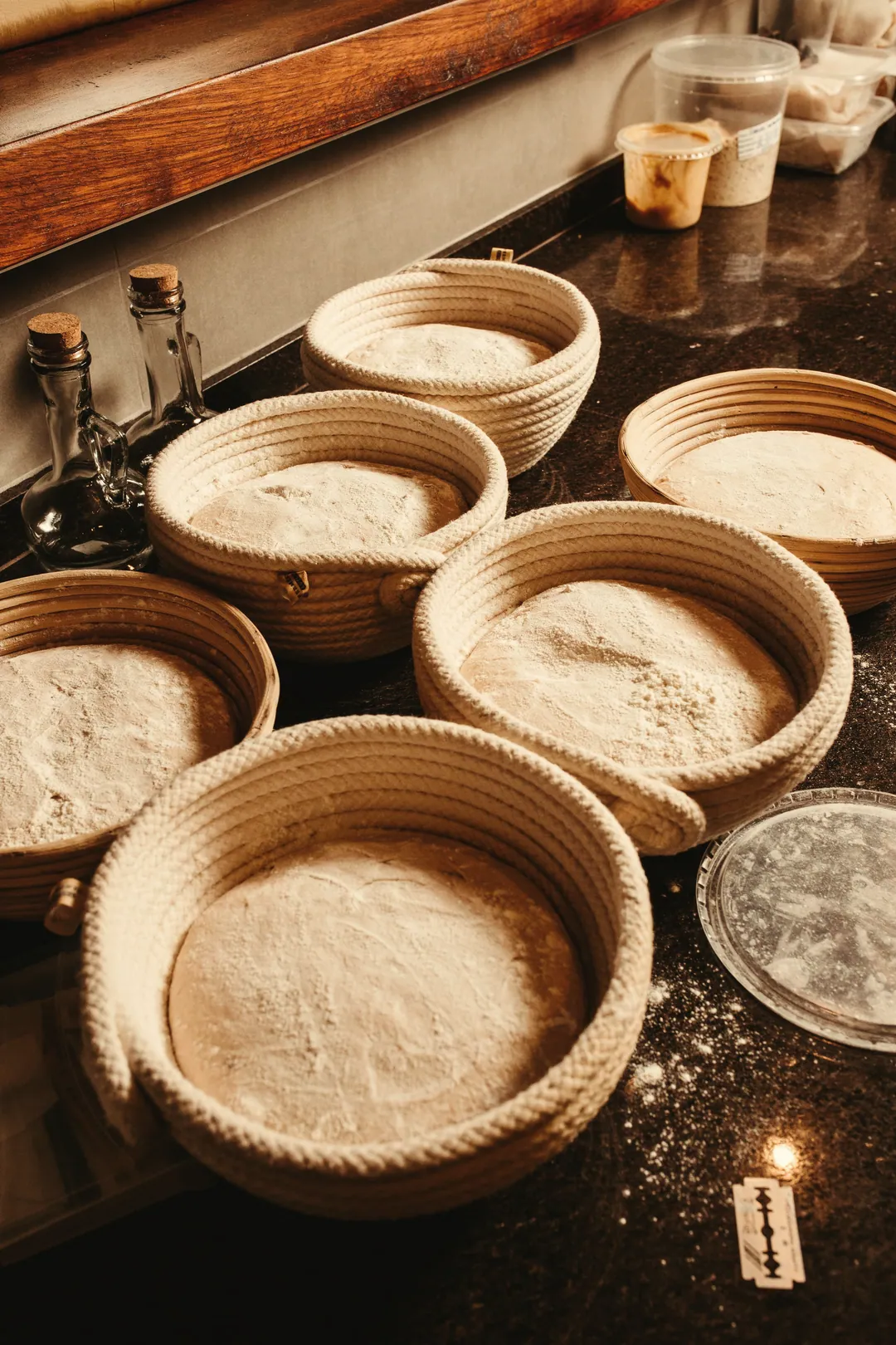Rows of dough proving in floured cane baskets