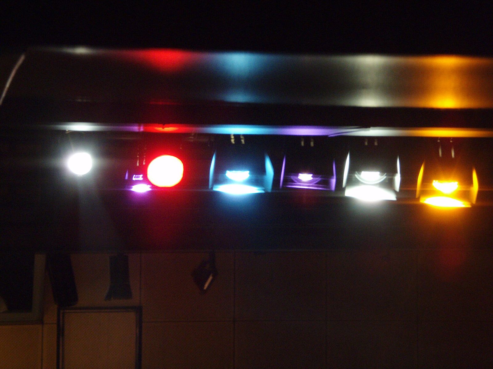 A row of PAR cans, each fitted with a different coloured filter