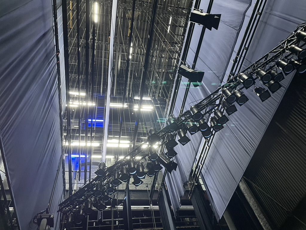 Looking up into a theatre's grid of lighting bars and lanterns