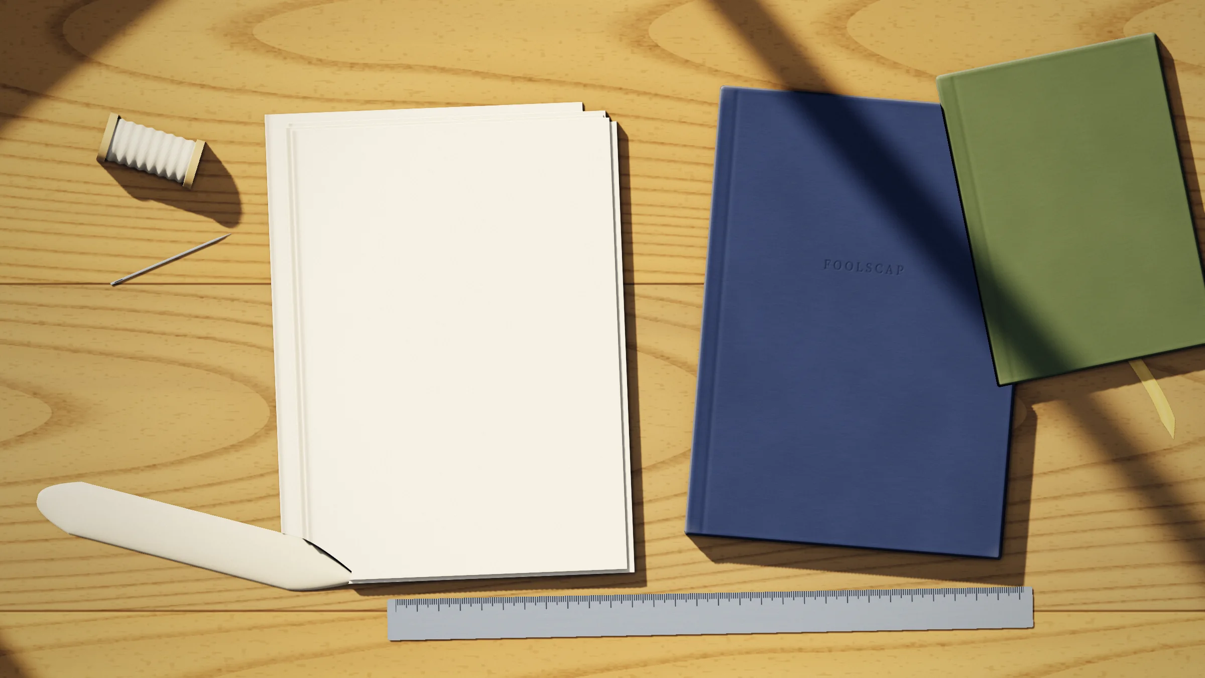 The back room bench: five folded signatures waiting to be sewn, finished navy and moss notebooks, a reel of linen thread, a needle, a bone folder and a steel rule
