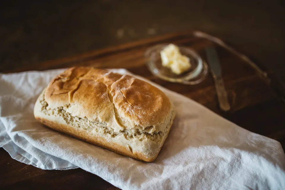 A loaf on a linen cloth with a dish of butter