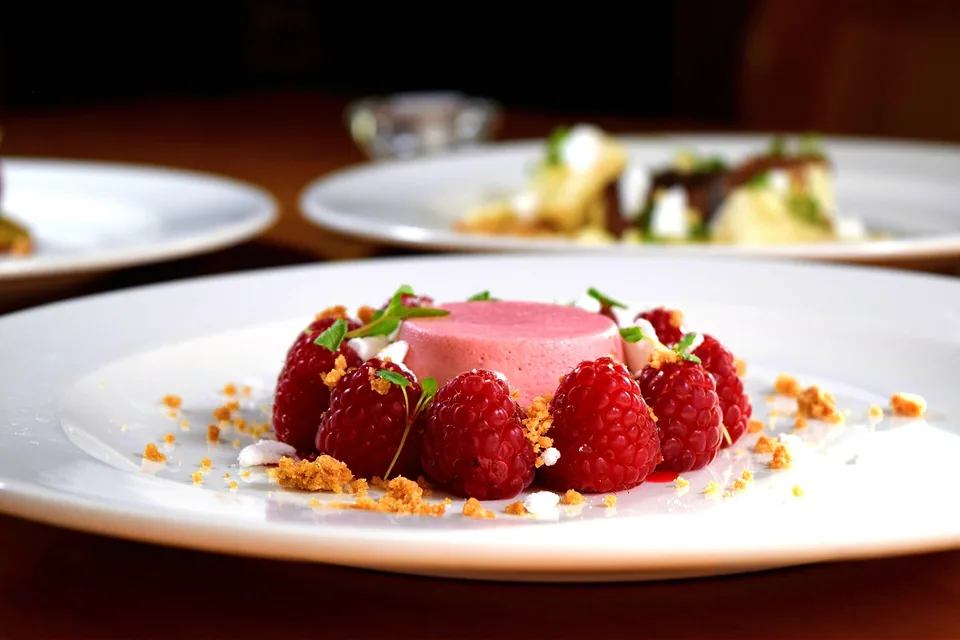 A pink pudding ringed with raspberries on a white plate