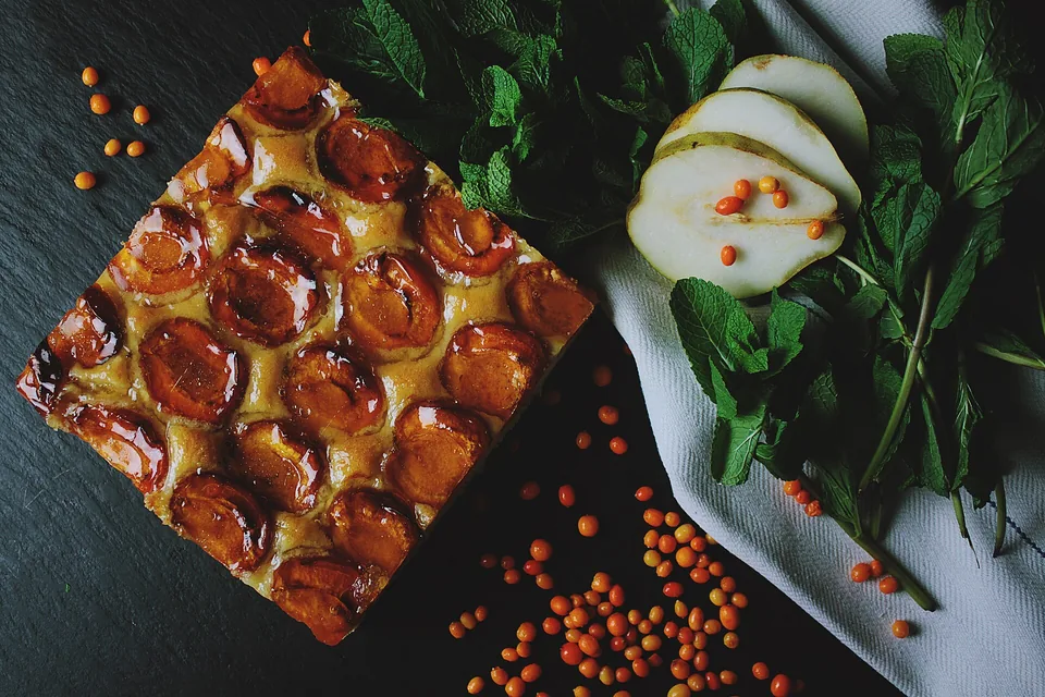 A square plum and almond tart on slate
