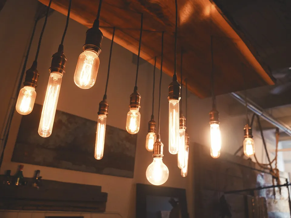 Filament bulbs hanging at different heights under a timber ceiling