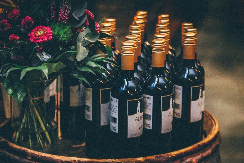 Bottles of wine in a barrel with a bunch of flowers