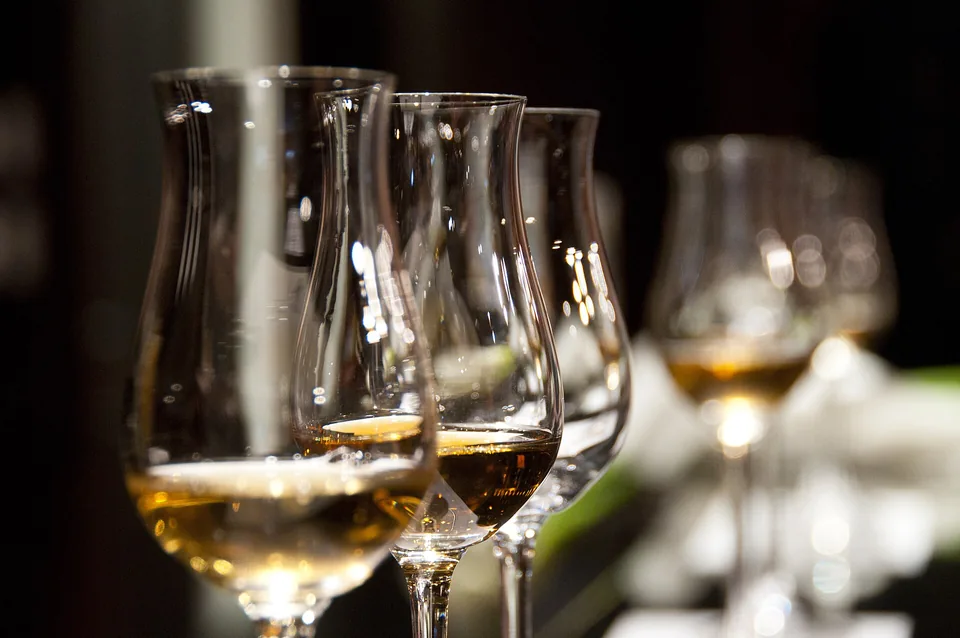 A row of tulip glasses with amber wine catching the light