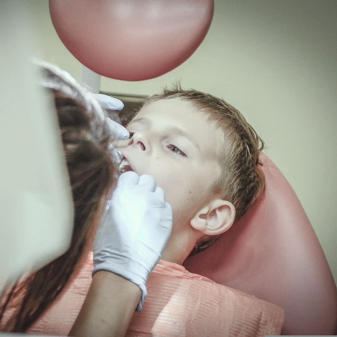 A boy in the chair having his teeth checked