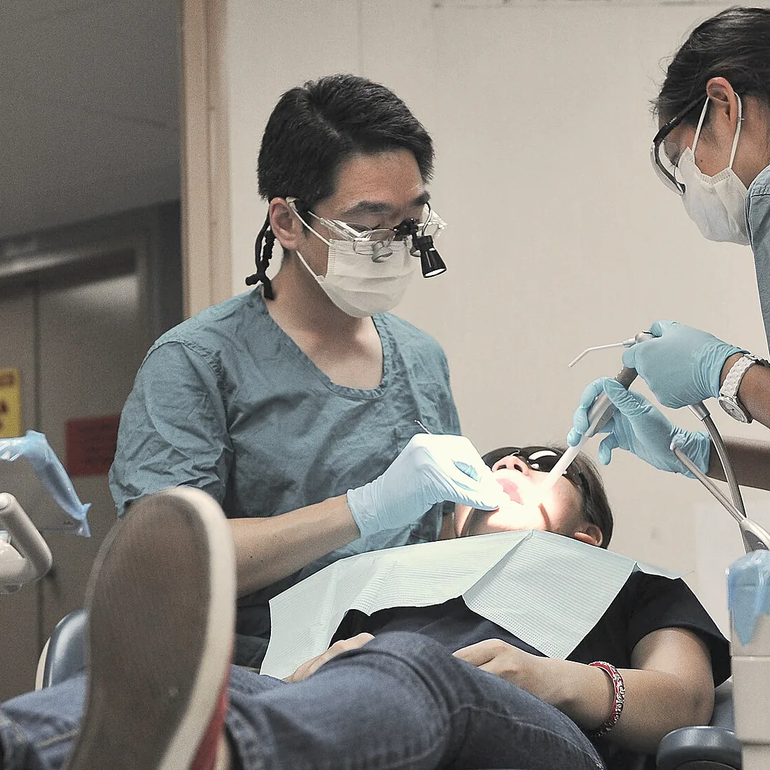 A dentist with loupes and his nurse during a root canal treatment