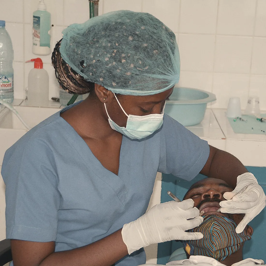 Priya Nair, hygienist, cleaning a patient's teeth