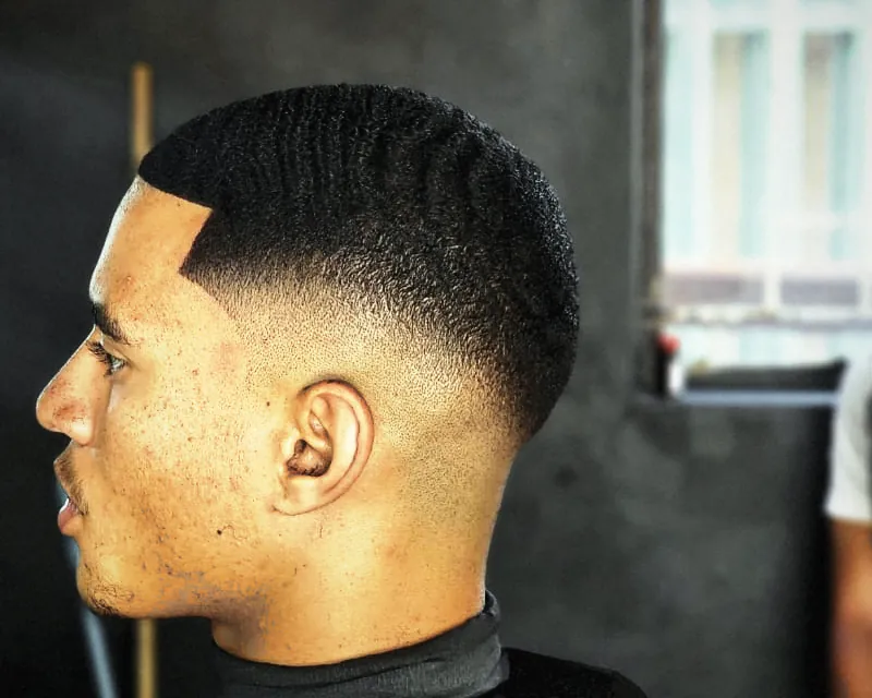Side view of a mid fade: skin behind the ear, getting darker up to the top