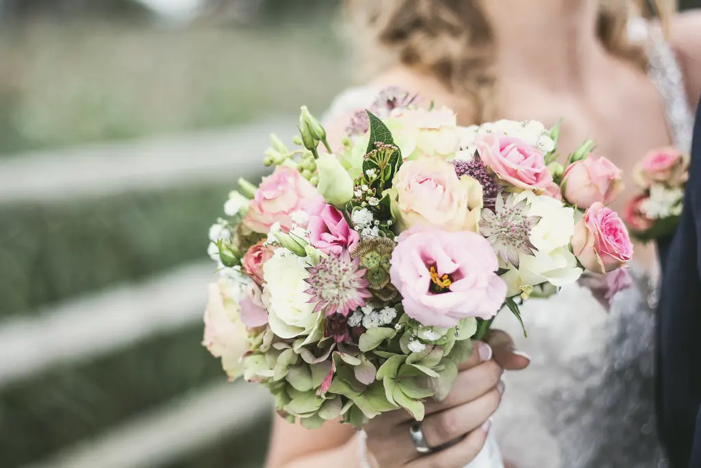 A bridal bouquet of lisianthus, roses and green hydrangea