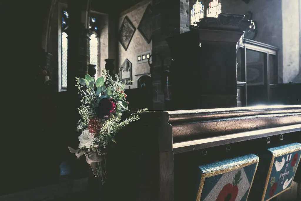 A bouquet resting at the end of a church pew