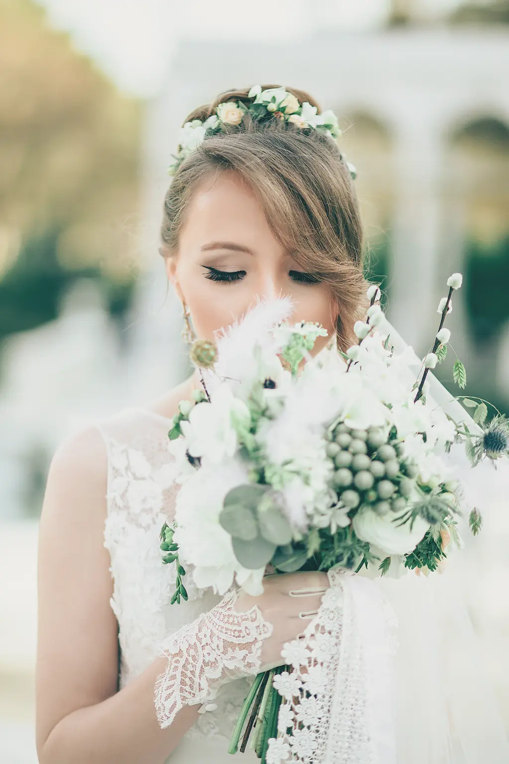 A bride with a bouquet of white roses and green berries