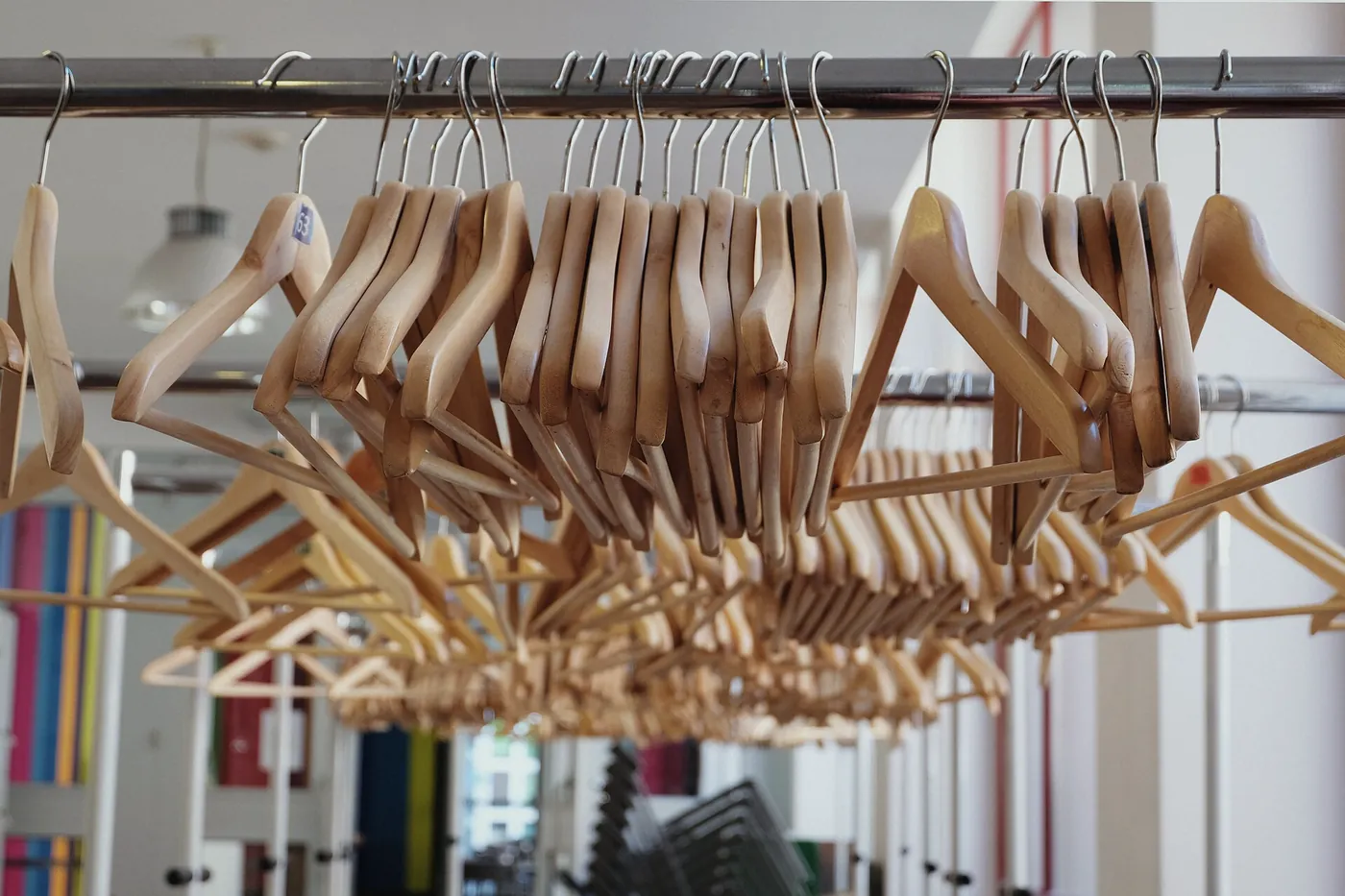 Empty wooden hangers bunched together on a rail