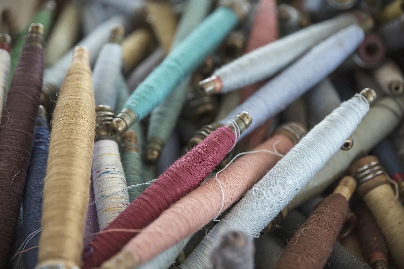 A heap of wound threads in faded blues, pinks and creams from the back room