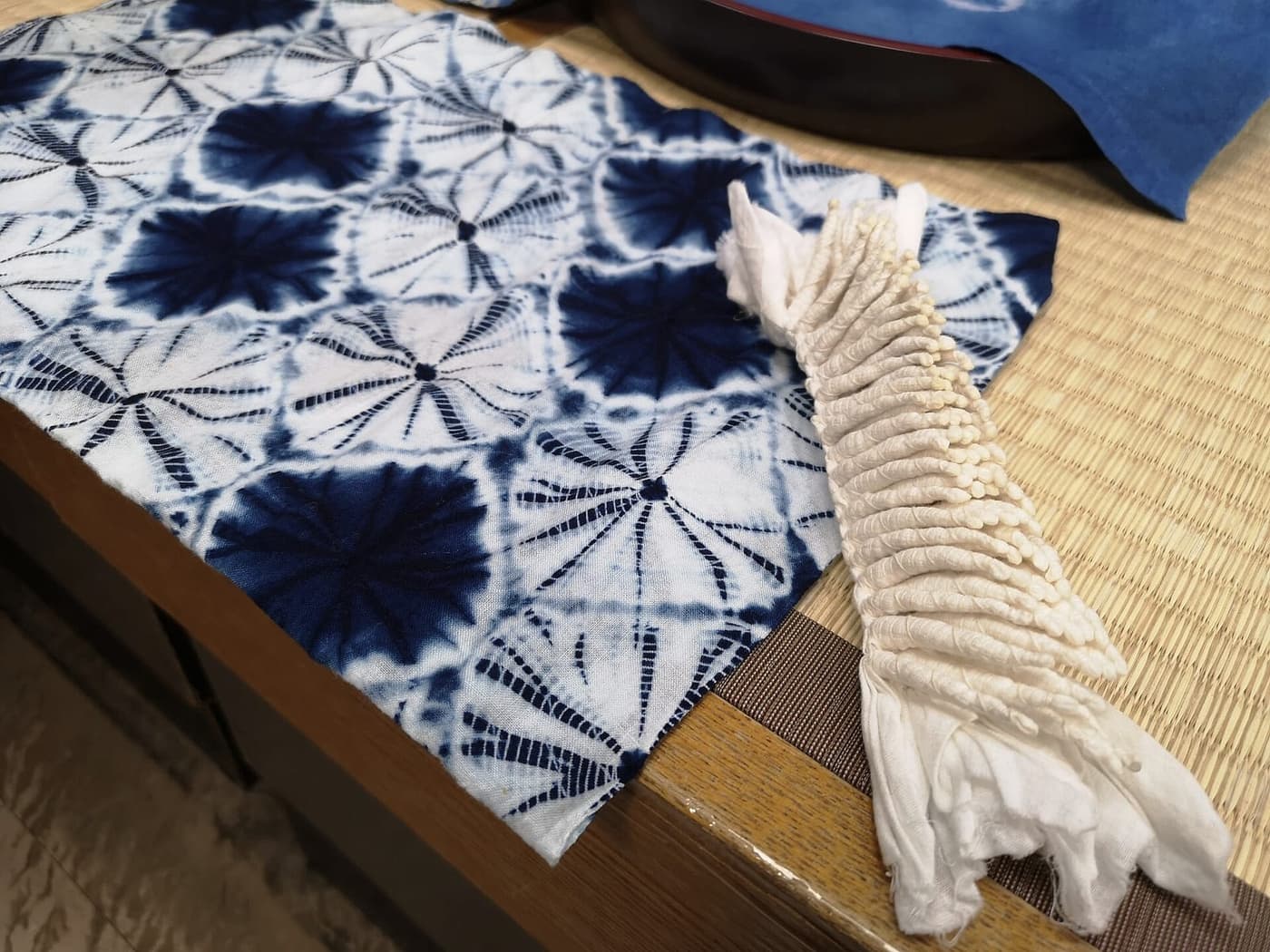 Kumo shibori: a bound piece of cloth beside the finished dyed piece