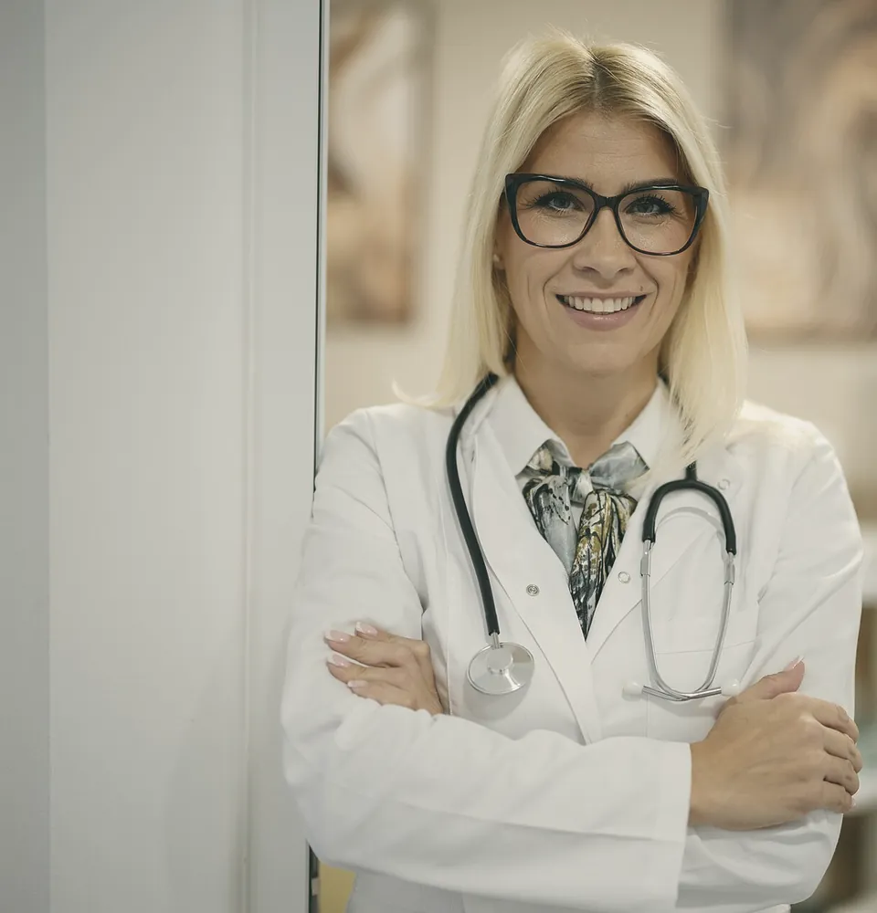Dr Clara Voss in her white coat, arms folded, smiling.