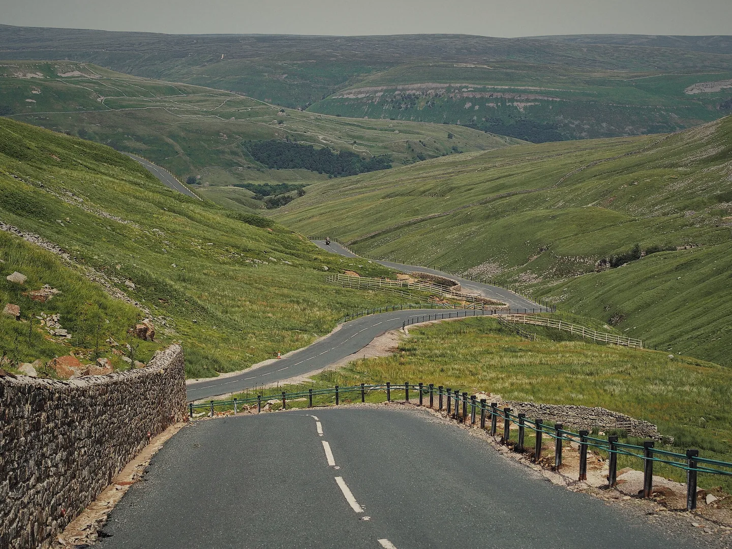 The Buttertubs Pass road winding down a steep green valley