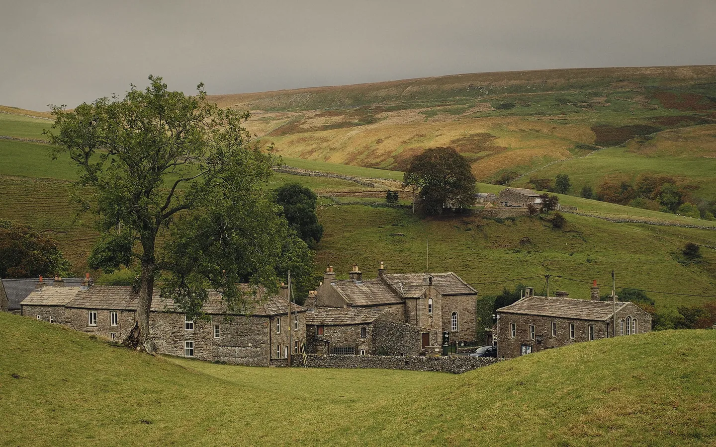 Keld: stone houses and barns on a green hillside above the river
