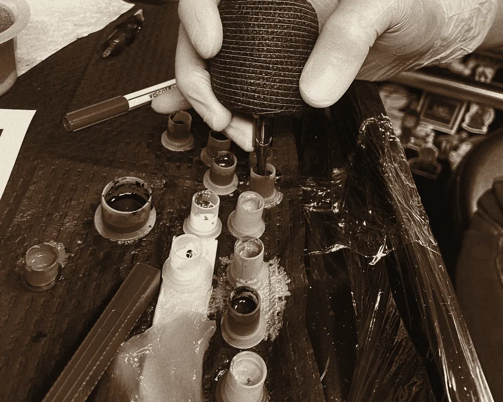 Ink caps on a tray covered in barrier film, the machine being loaded