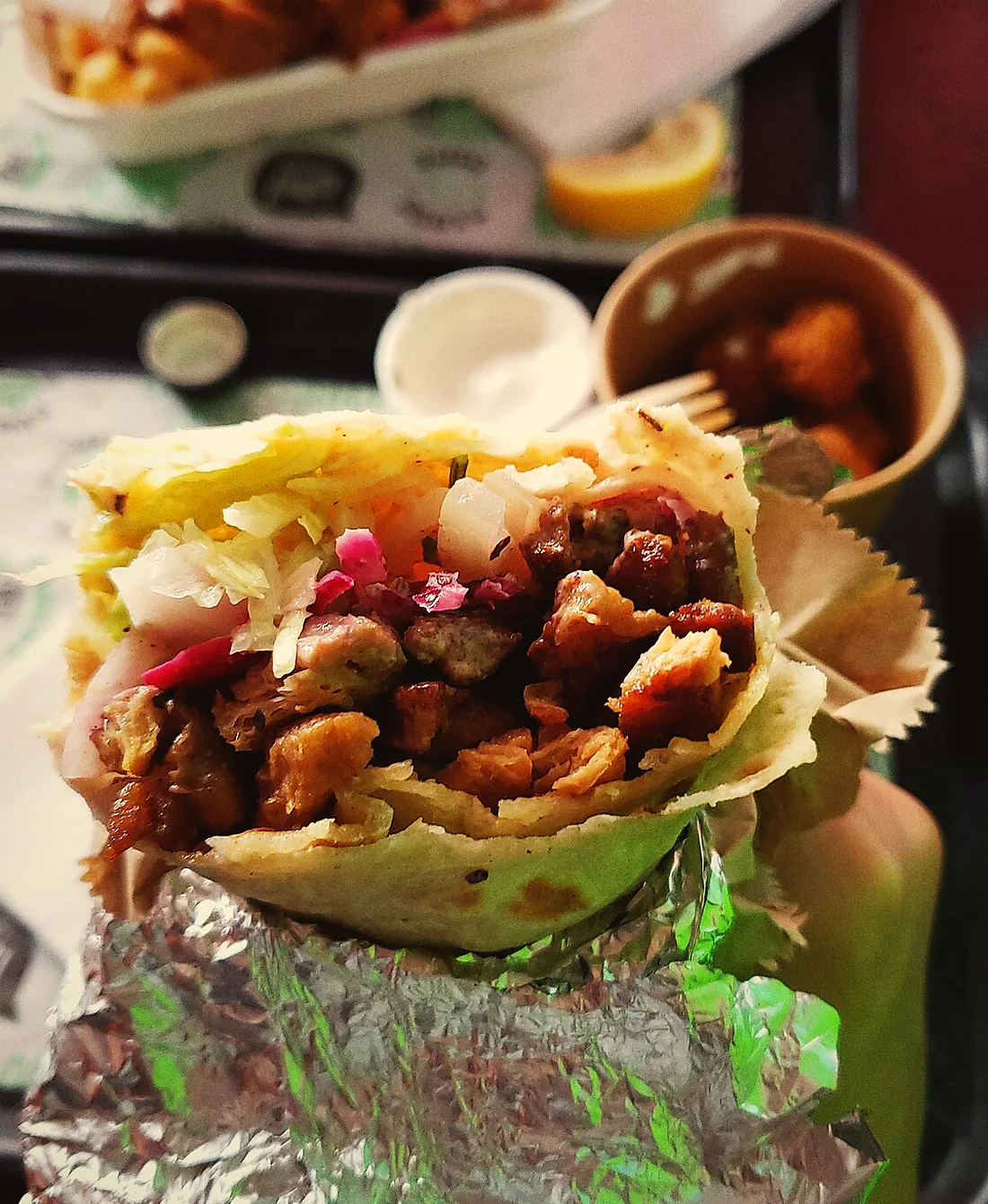 Chicken shawarma wrap in foil with pink pickles