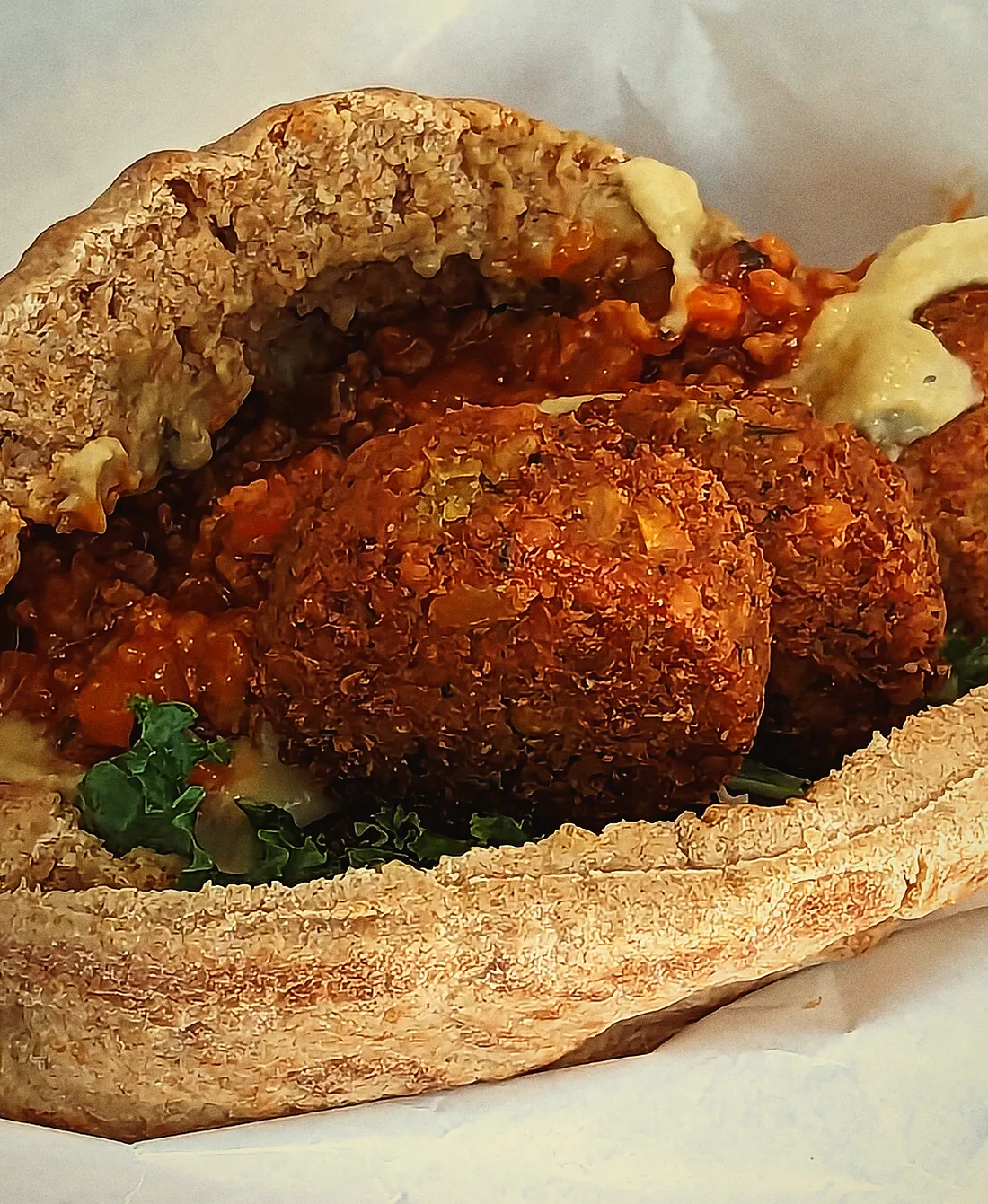 Falafel stuffed into bread with salad and sauce