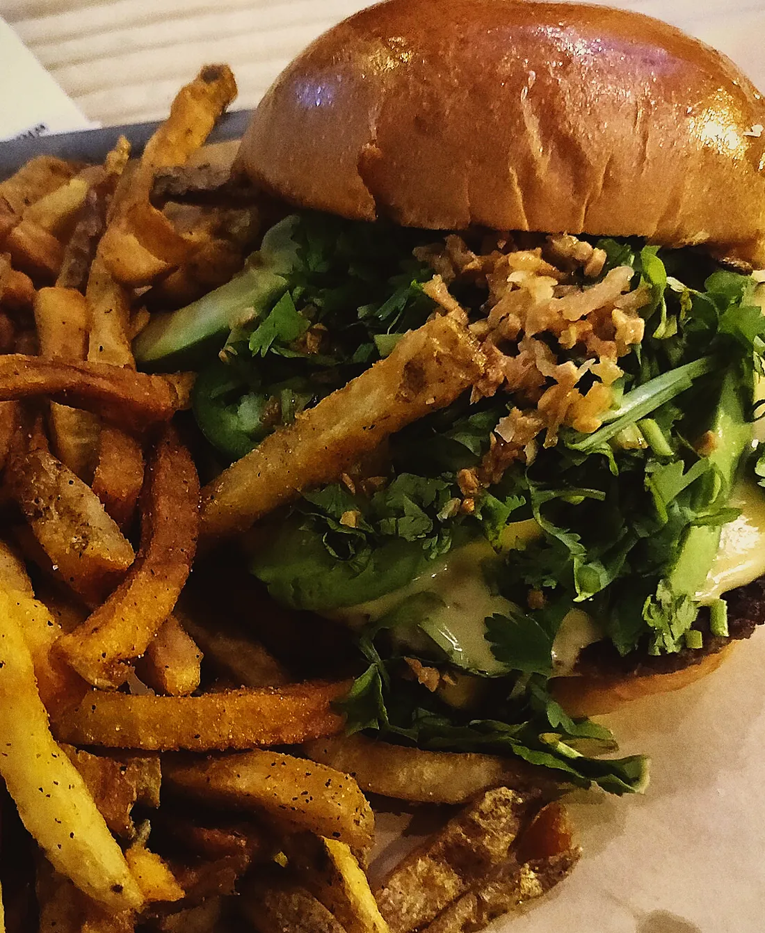 Smash burger with fries on a paper-lined tray