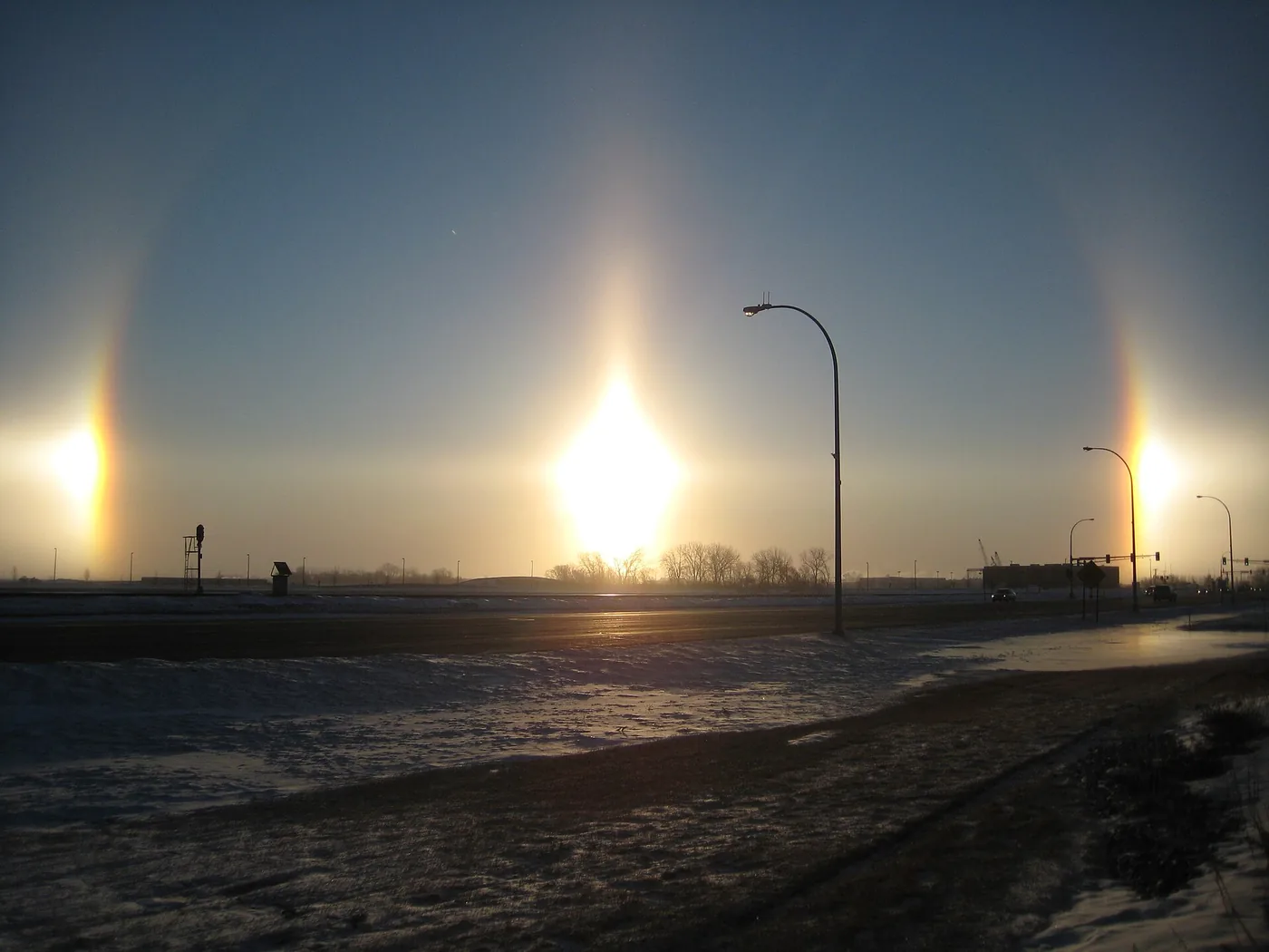 Two sun dogs either side of a low Sun over a snowy road in Fargo