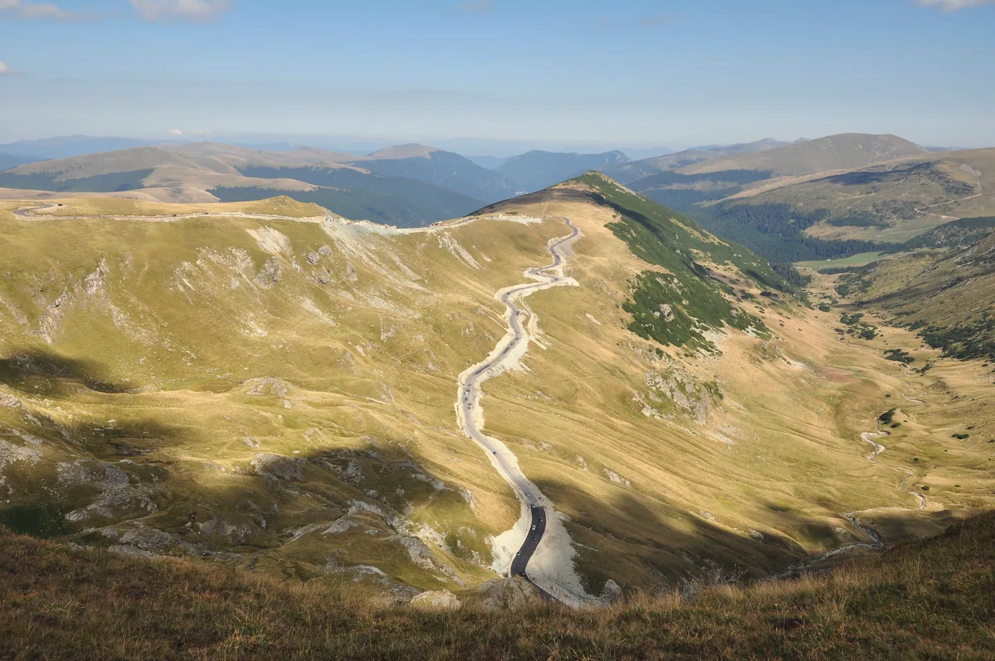Transalpina urcând în serpentine spre creastă, într-o zi senină de vară