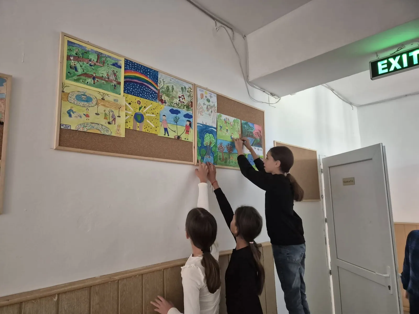 Hol al școlii cu lucrările elevilor prinse pe panouri de plută
