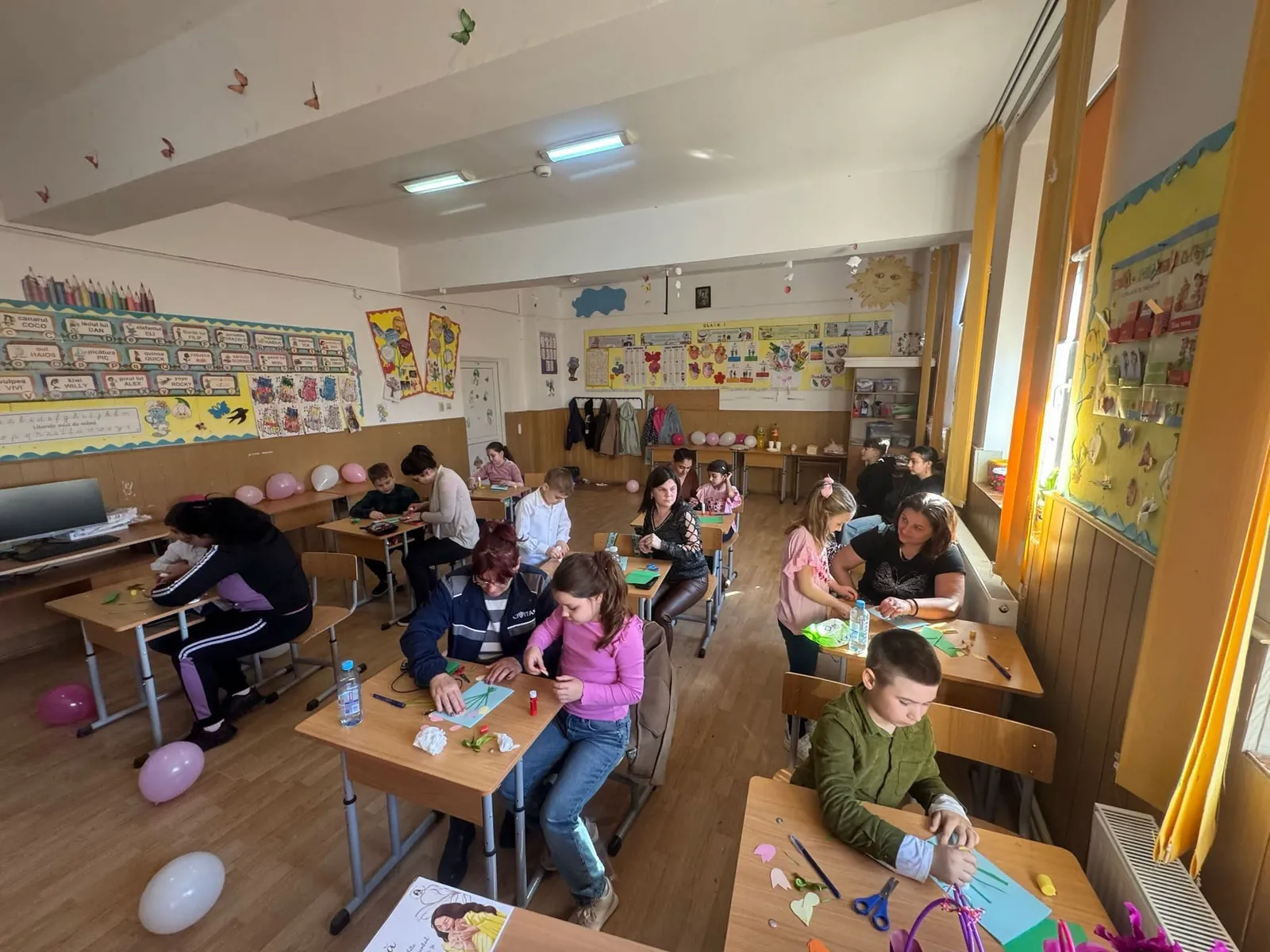 Sală de clasă în timpul unui atelier, cu mese grupate