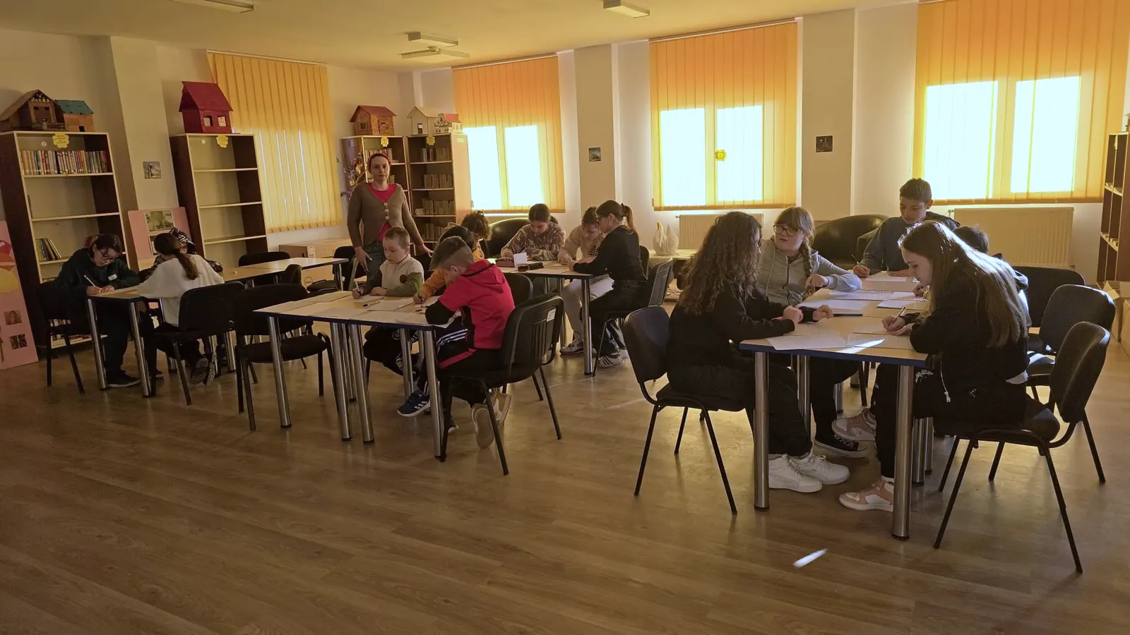 Sala CDI cu rafturi de cărți, mese și un ecran mare, în timpul unei activități