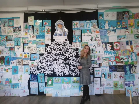 Expoziția de desene de iarnă văzută din lateral, cu profesoara organizatoare