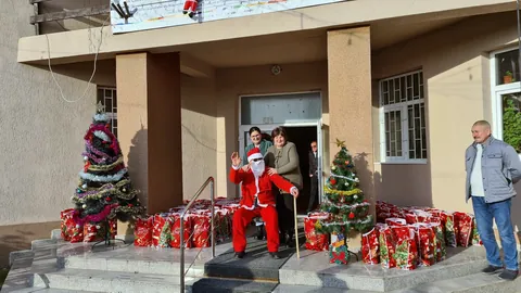 Intrarea principală a școlii, cu brazi împodobiți și cadouri pe trepte