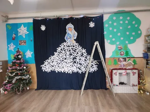 Scena decorată de iarnă, cu un copac din fulgi de hârtie și un brad
