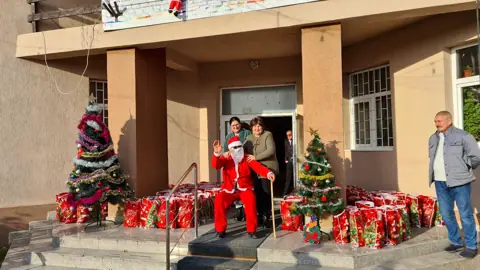 Intrarea principală a școlii cu Moș Crăciun și cadouri (Primăria Bârza, dec. 2023)
