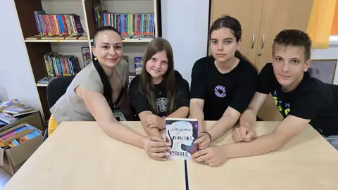 Echipă CDIdei în cărți 2024 cu cartea, bibliotecă